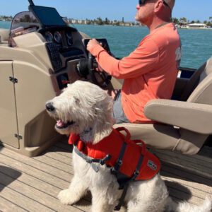 A man and his dog are on the boat.