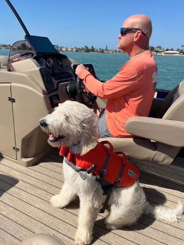 A man and his dog are on the boat.